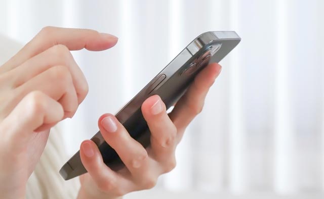 家族葬の所沢市葬儀社に電話でお問合せしようとしている人の手元。